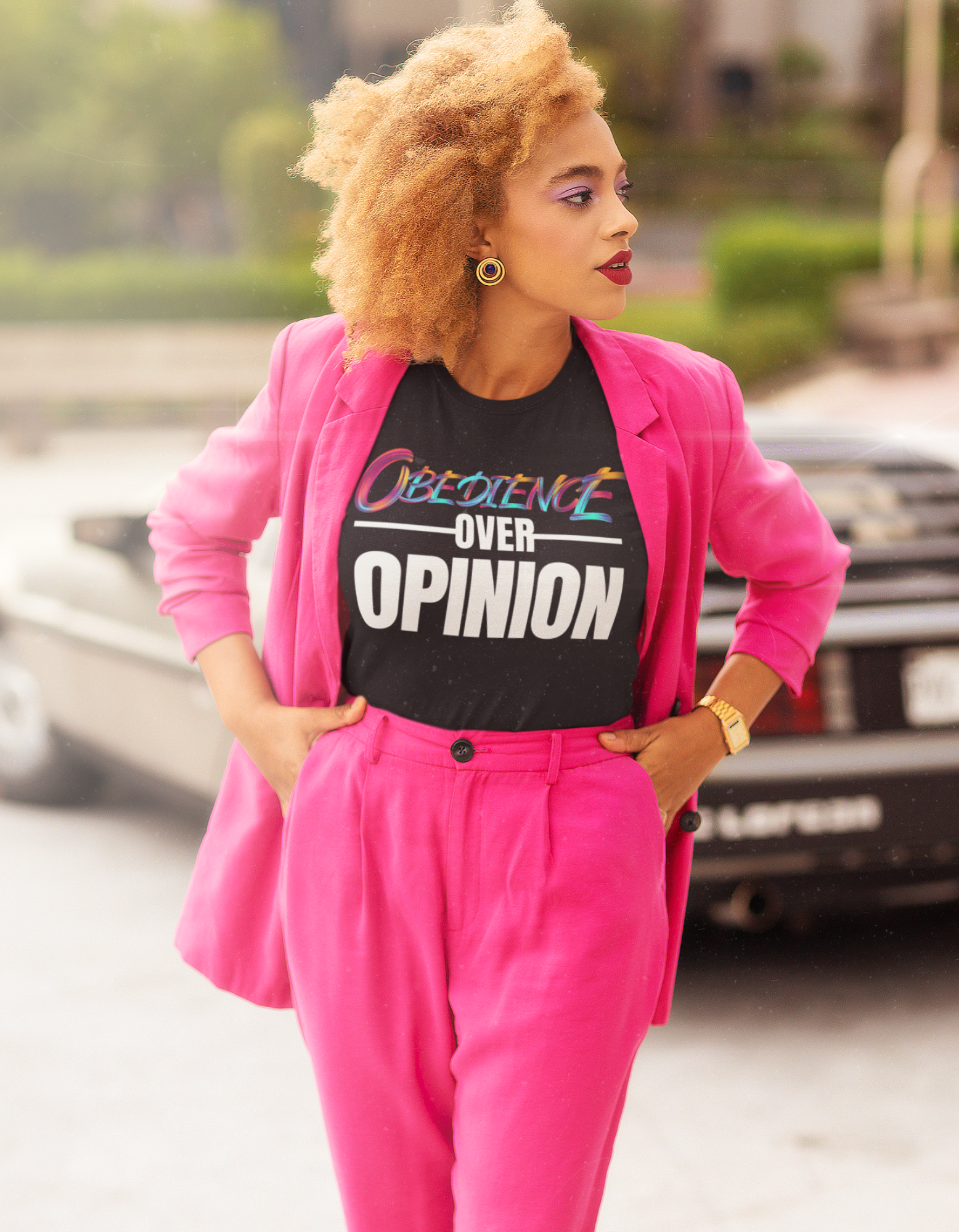 Obedience Over Opinion - Black T-Shirt - Layered by Pink Coat - Pink Pants - Almond Curly Hair - Woman